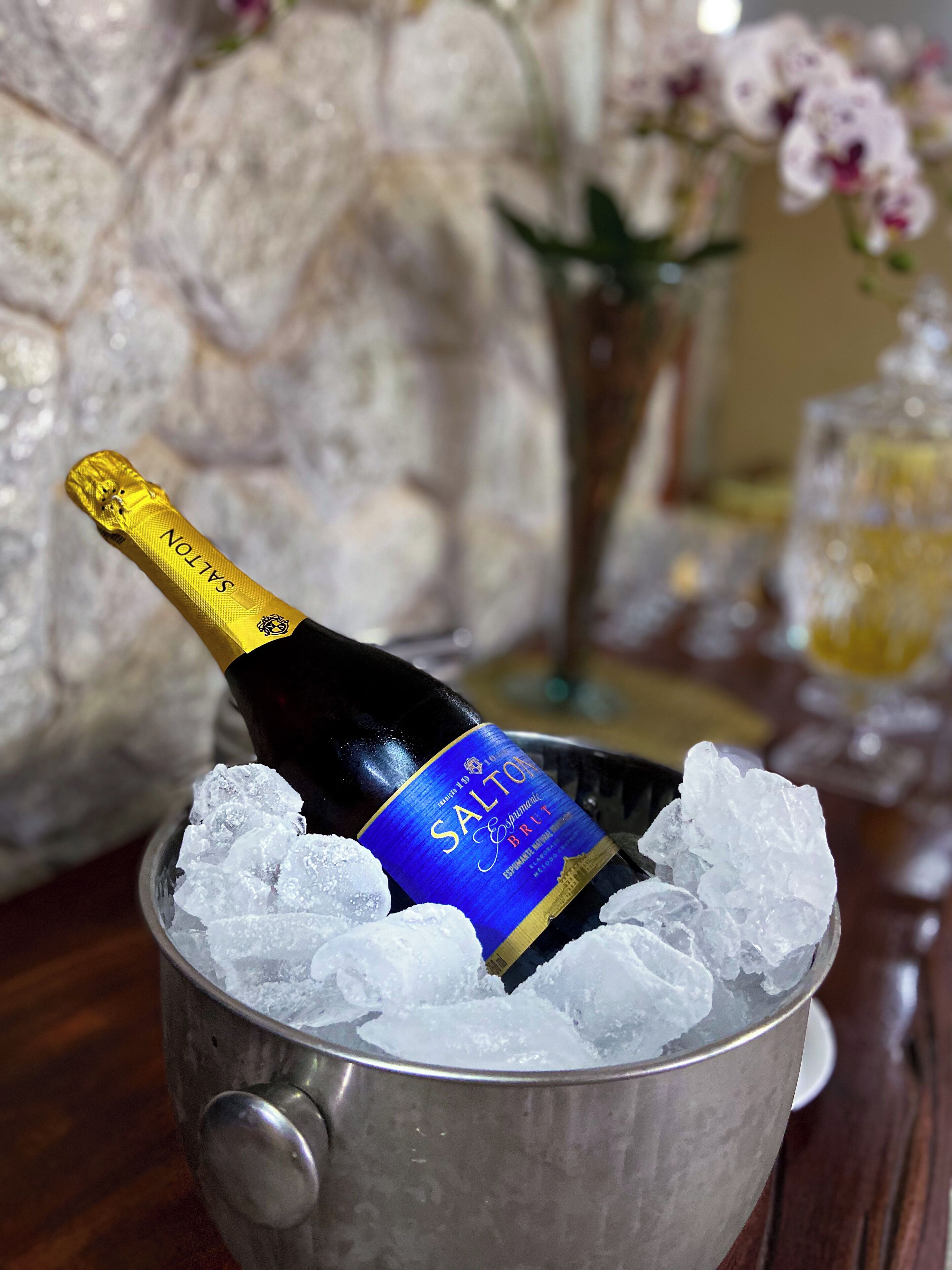 Een fles Salton champagne in een metalen emmer vol ijsblokjes.