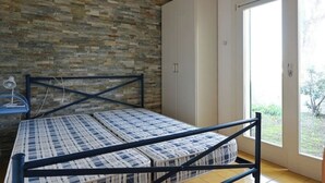 Ein Zimmer mit einem Bett, einem Kleiderschrank und einem Fenster.