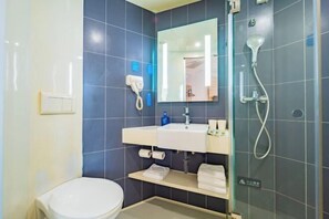 Un baño moderno con inodoro, lavabo y ducha.