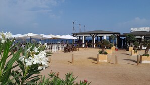 Ein Restaurant direkt am Strand mit Außenbestuhlung und Meerblick.