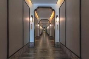 A long, narrow hallway with walls on both sides and a series of lights along the ceiling. - Zhouchun Hotel (Zibo)