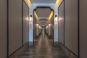 Un pasillo largo y estrecho con paredes a ambos lados y una serie de luces a lo largo del techo.