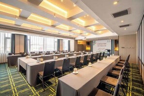 A conference room with a long table, chairs, and a projector screen. - Zhouchun Hotel (Zibo)