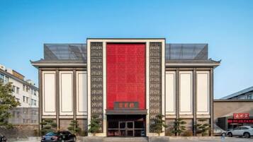 Un edificio con un llamativo muro rojo y un estilo arquitectónico tradicional.