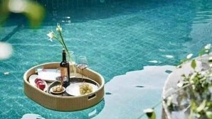 A clear pool with a floating lounge chair and a floating table with drinks and snacks. - Zenity Apartment Quan 1 (Ho Chi Minh City)