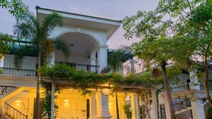 A hotel entrance with a covered porch, steps leading up to the entrance, and bicycles parked in front.