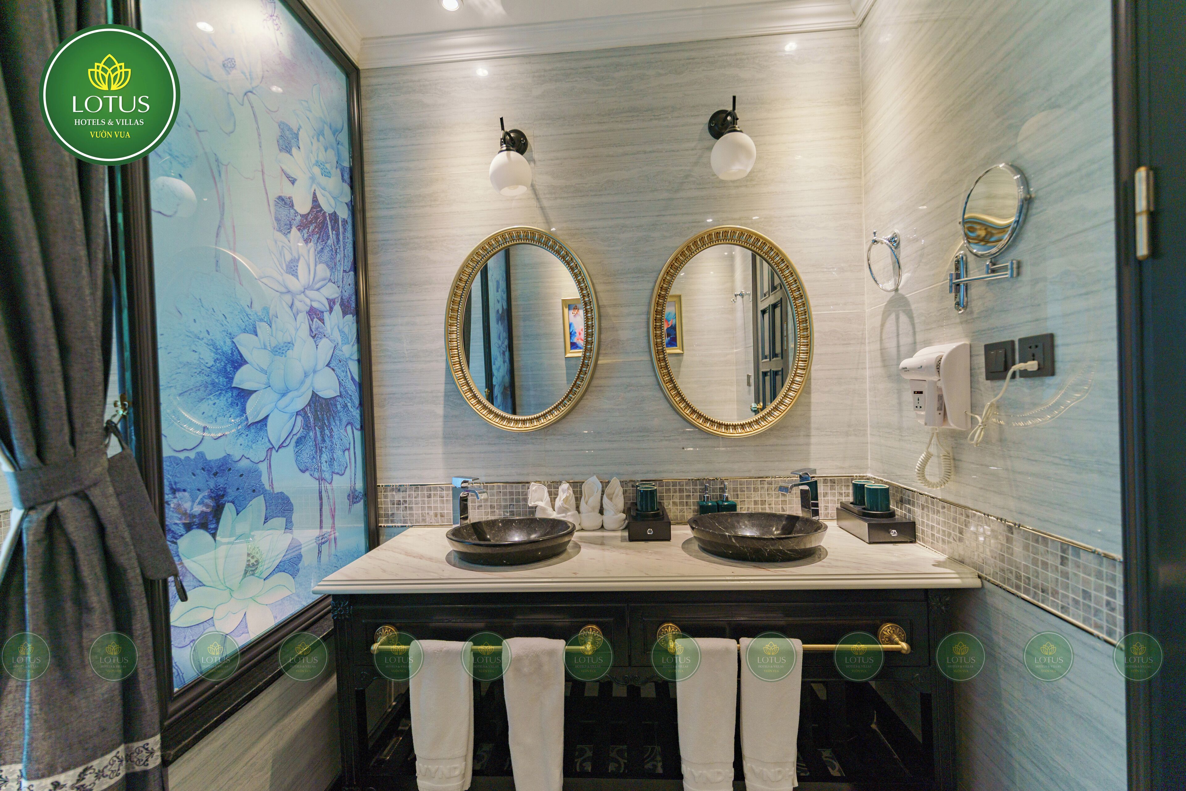 Casa de banho com duas pias, um espelho grande e um janelão decorado com motivos florais.