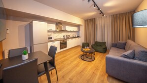A modern living space with a dining area, kitchen, and seating area. - Blloku Unique Apartments 2 (Tirana)