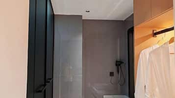 Ein modernes Badezimmer mit Duschkabine aus Glas, einem weißen Waschbecken und einem Handtuchhalter.