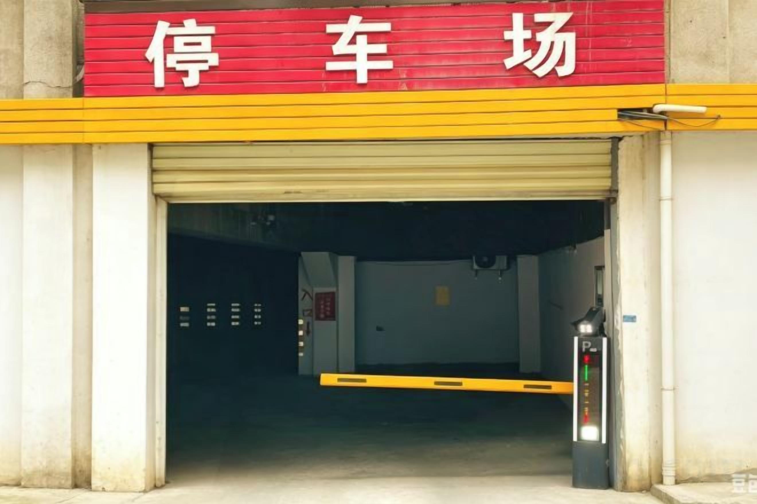 A garage entrance with a red and yellow sign, a closed garage door, and a fire extinguisher on the right.