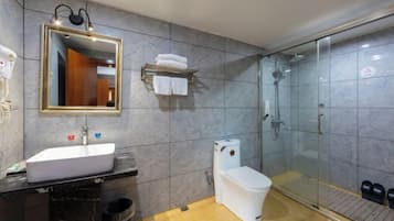 A modern bathroom with a white sink, a toilet, and a glass-enclosed shower.