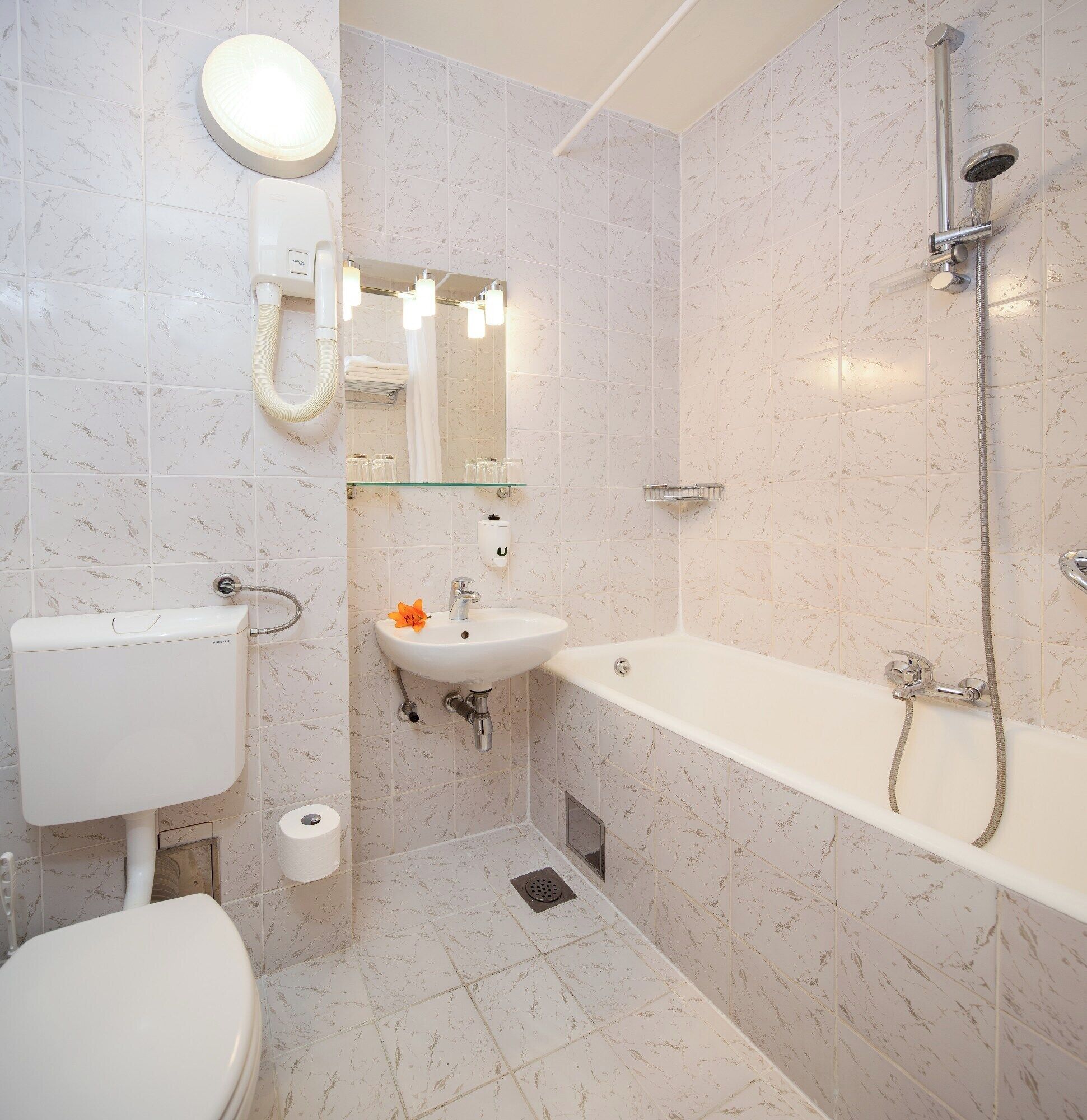 A modern bathroom with a toilet, sink, and bathtub.