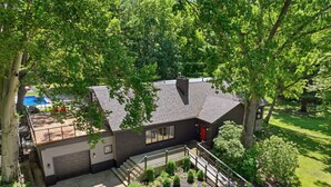 A two-story house with a covered patio, a fenced yard, and a small garden.
