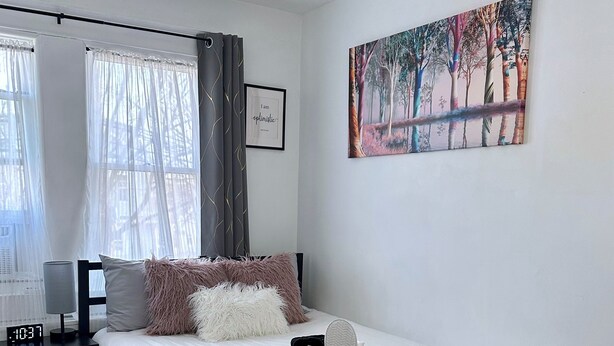 Une chambre à coucher avec un lit, une table de chevet et un tableau accroché au mur.