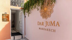 The entrance to Dar Juma in Marrakech, featuring a decorative wall with the hotel's name and a signboard listing amenities. -  Riad Dar JuMa Marrakech Suites:Jacuzzi - Piscine & Spa (Marrakech)