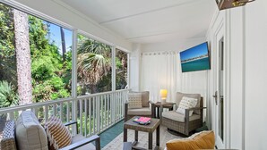 A covered outdoor seating area with wicker furniture, a table, and a view of the outdoors. - Grayton Time - Grayton Beach, Heated Private Pool, Walk to the Beach + Red Bar! (Grayton Beach)
