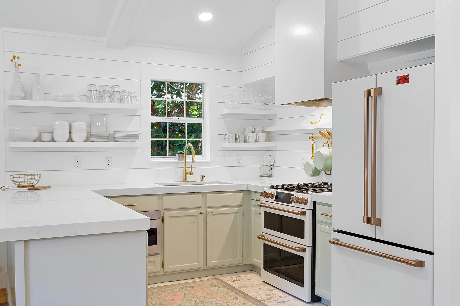 A modern kitchen with white cabinetry, a stainless steel refrigerator, and a gas stove.