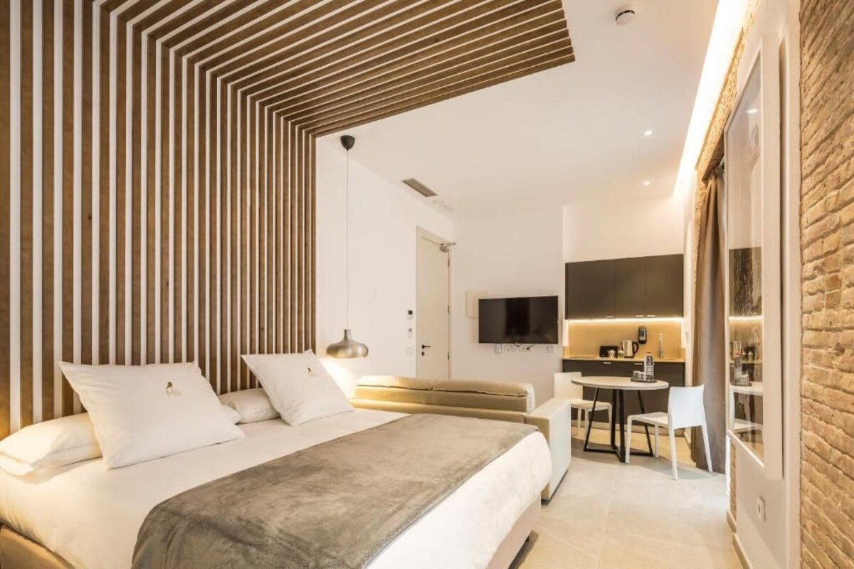 Une chambre d’hôtel moderne équipée d’un lit, d’un canapé, d’un coin repas et d’une cuisine.