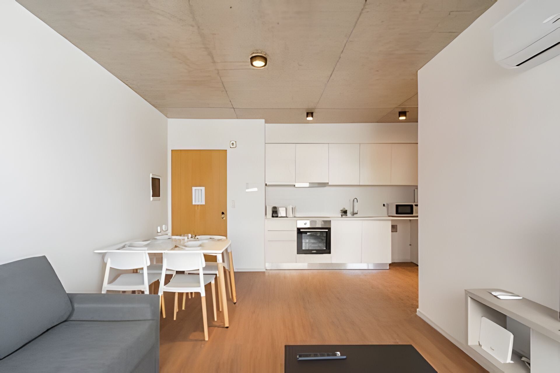 A modern apartment with a dining area, kitchen, and living space.