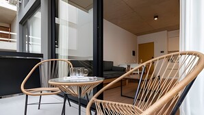 A modern interior with wicker chairs and a glass table, a sofa, and a dining area. - Urban Rent - Departamentos en el corazon de Belgrano (Buenos Aires)