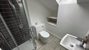 Ein Badezimmer mit Dusche, Toilette und Waschbecken.