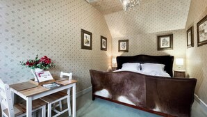 A bedroom with a large bed, a desk with a chair, and a chandelier. - 1 bedroom accommodation in East Tytherley (East Tytherley)