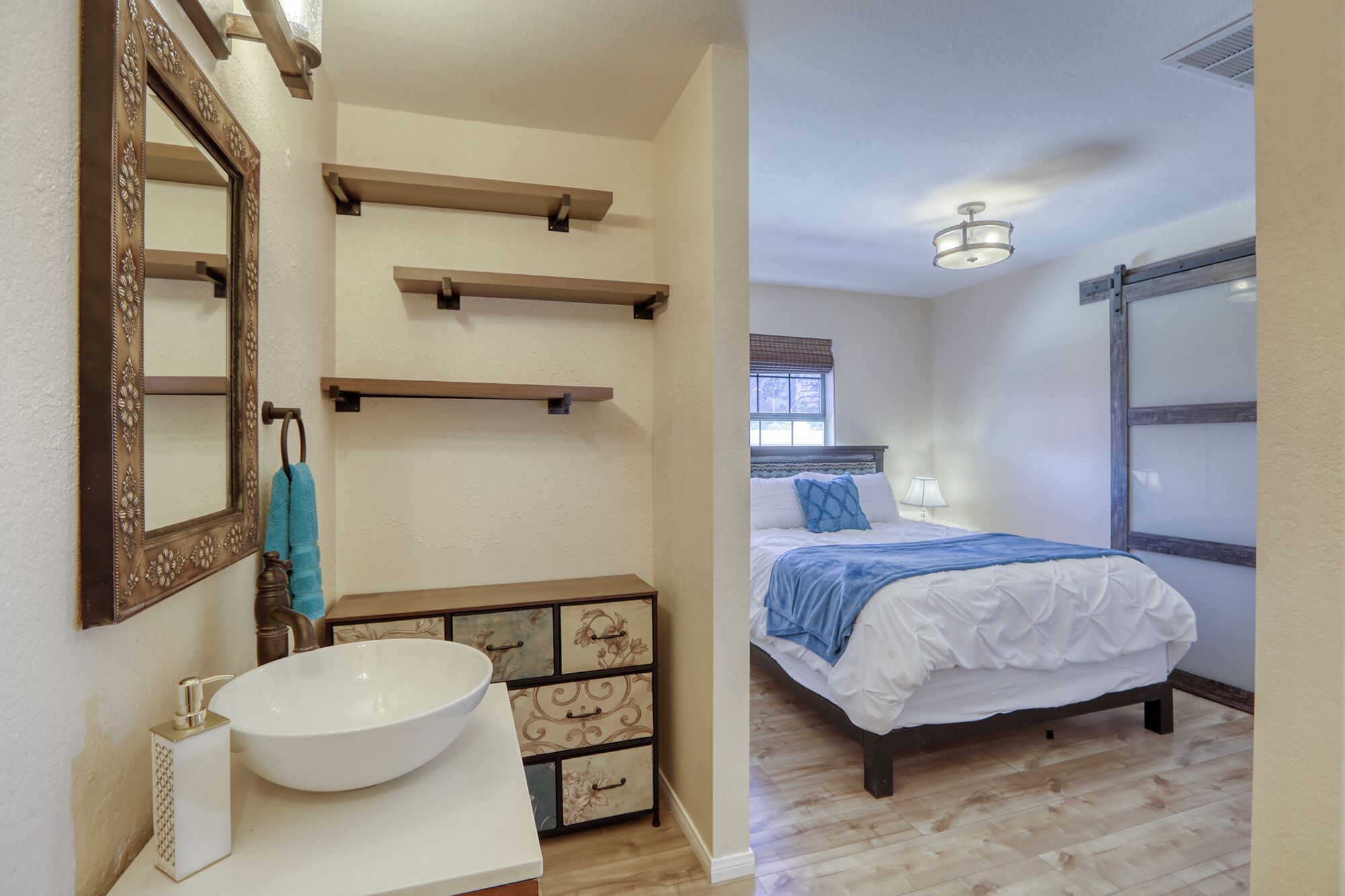 Une salle de bain avec un grand miroir, un lavabo blanc et un meuble décoratif.