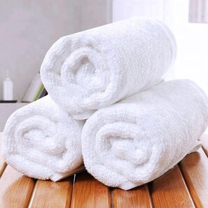 Three white towels stacked on a wooden surface. - Il Ciclamino (Melendugno)