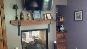 A living room with a fireplace, television, and wooden furniture. - Paradise. Front deck. All comforts of home.  Great view. Serenity. (Keuka Park)
