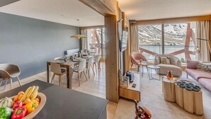 Un interior moderno con comedor, cocina y sala de estar con balcón.
