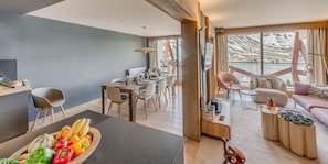 A modern interior with a dining area, a kitchen, and a living space with a balcony.