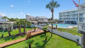 Un hôtel doté d’une piscine, de palmiers et offrant une vue sur les bâtiments environnants.