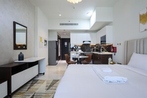 Ein Hotelzimmer mit Bett, Nachttisch und Blick auf den Küchenbereich.