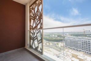 Un balcón con vistas a un paisaje urbano, incluyendo un edificio grande en construcción.