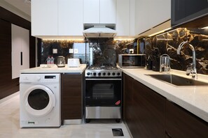 Eine moderne Küche mit eingebautem Waschmaschine, Backofen und Mikrowelle.