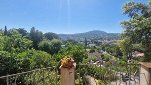A balcony with a view of a town and hills in the distance. - Apartment with garden in Sainte-Maxime (Sainte-Maxime)