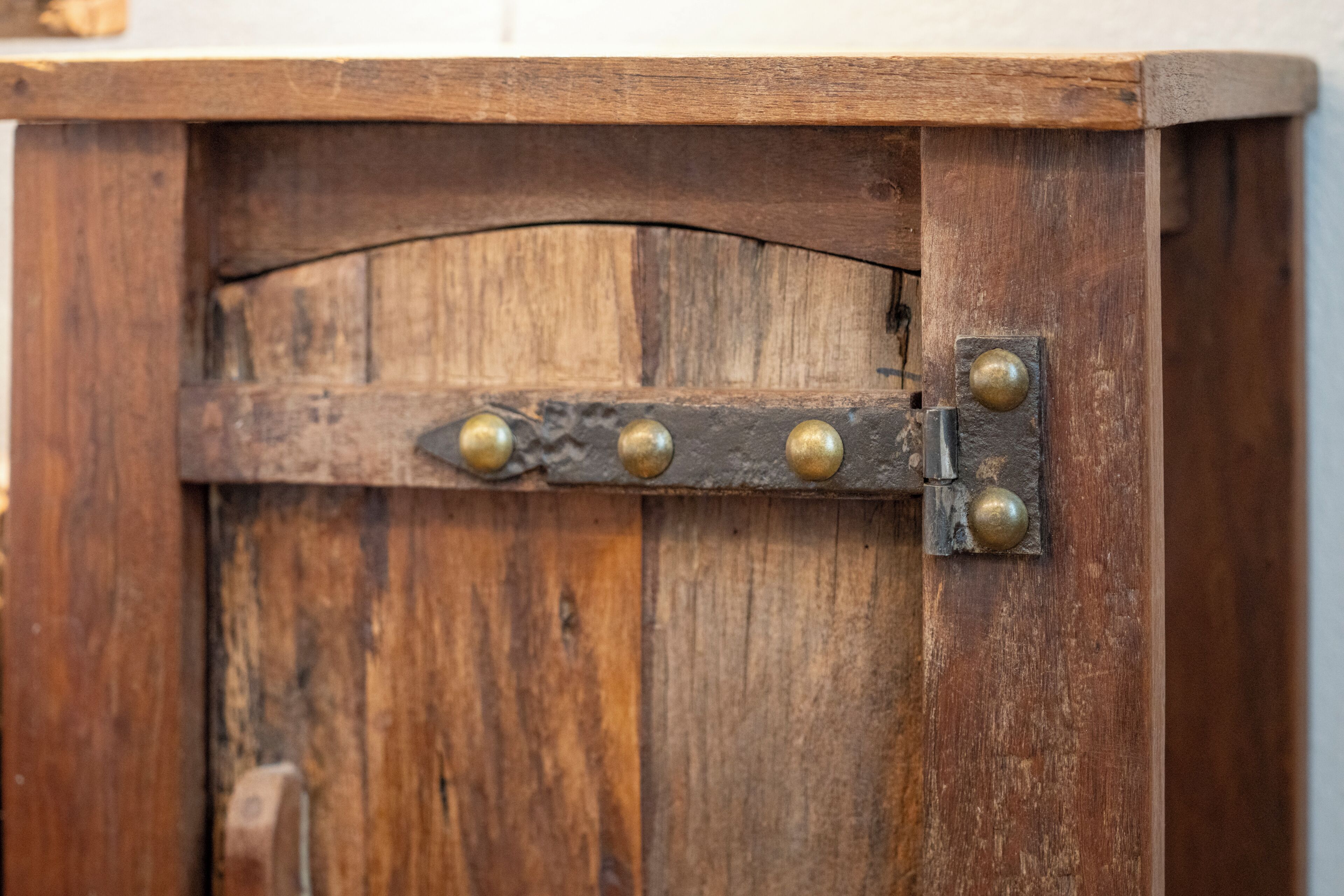 Una puerta de madera con un cerrojo metálico y un panel de madera curvada.