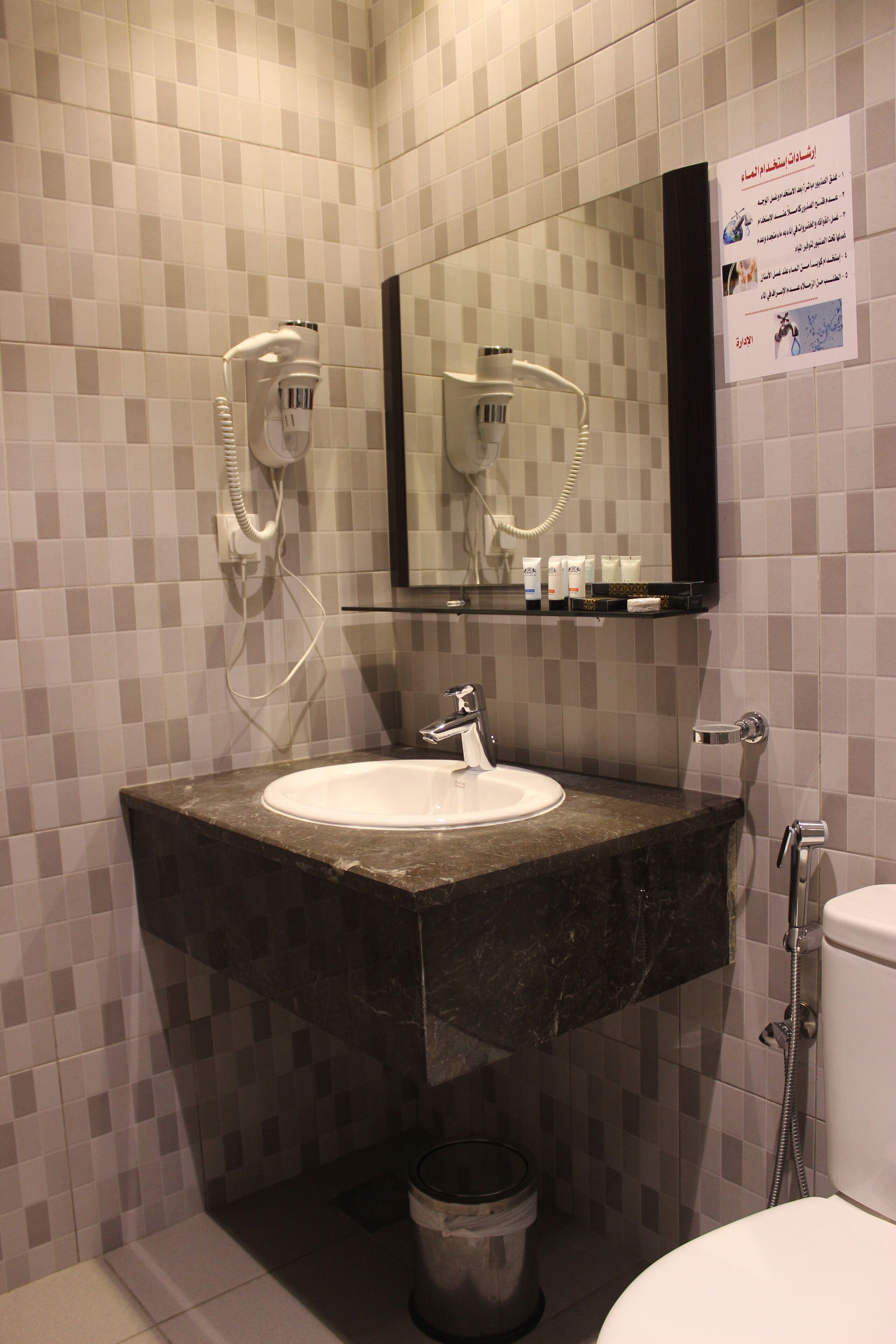 A bathroom with a sink, mirror, and shower.