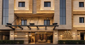 Ein Hotel Eingang mit einem Schild, auf dem 'Palm Boutique Hotel & Hospitality Suites' steht.