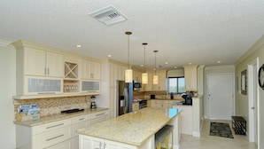 A spacious kitchen with white cabinetry, granite countertops, and modern appliances. - Siesta Key Stunner Endless Gulf Views from Your 2 Bed 2 Bath Top Floor Escape (Siesta Key)