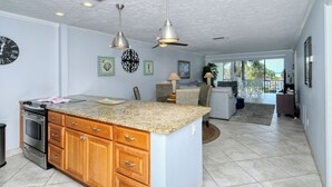 A spacious kitchen with granite countertops, wooden cabinets, and stainless steel appliances. - Siesta Key Beach 2 Bed 2 Bath with Gulf Views Steps to Beach (Siesta Key)