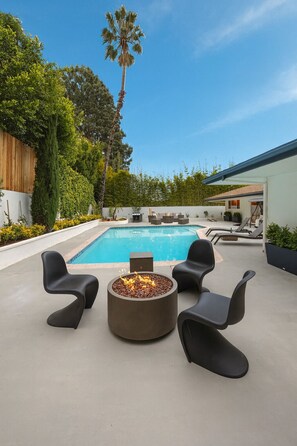 A poolside area with a fire pit, outdoor seating, and a view of the pool. - Charming Hollywood Hills Villa: Heated Pool, Unique Design, Peaceful and Private (Los Angeles)