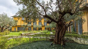 Un edificio amarillo con un gran árbol en primer plano.