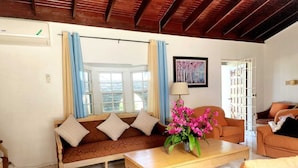 A living room with a sofa, armchairs, a coffee table, and a painting on the wall. - Jamaica Dream Villa - Iron Shore Escape (Montego Bay)