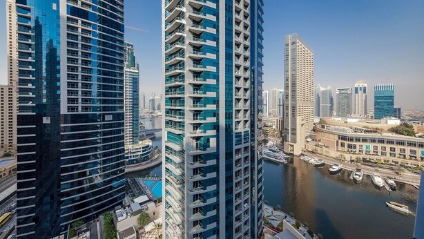 A high-rise building with a modern architectural design, featuring multiple balconies and a waterfront view. - Handsome 1BR in Bay Central Tower (Dubai)