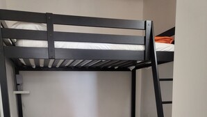 A bunk bed room with a desk and chair, a small shelf, and a tiled floor. - La Piccola Casetta nel Centro Storico (Iglesias)