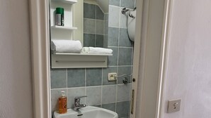 A bathroom with a white sink, a mirror, and a towel rack. - La Piccola Casetta nel Centro Storico (Iglesias)