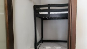 A small, narrow room with a bunk bed, a white radiator, and a tiled floor. - La Piccola Casetta nel Centro Storico (Iglesias)