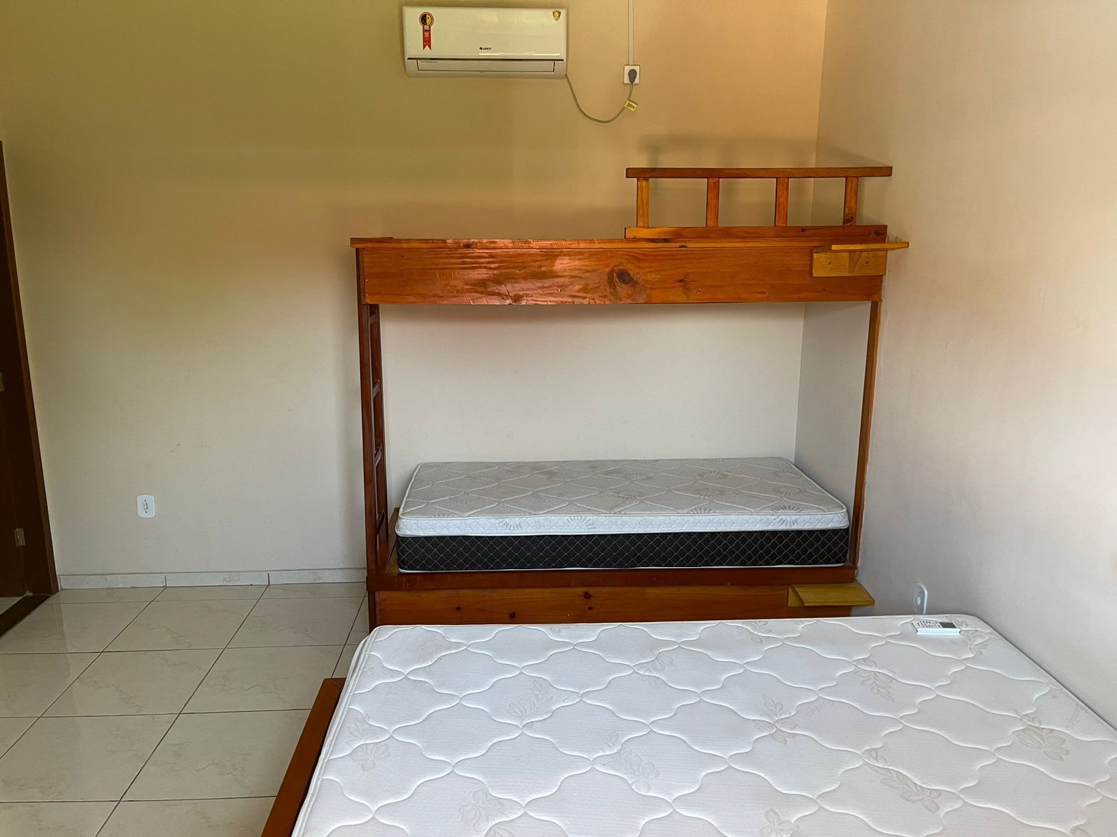 A bunk bed with a mattress and a wooden headboard.