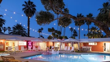 Una piscina al aire libre, sillones reclinables de piscina